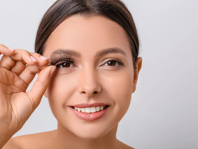 Verschillende make-up producten waaronder een standaard met 15 make up borstels, een oogschaduw pallet, een bronzer en meerdere nagellak potjes. Allemaal geplaatst op een witte tafel. 